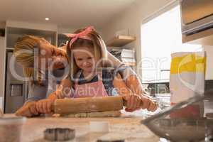 Mother with her daughter preparing food in kitchen