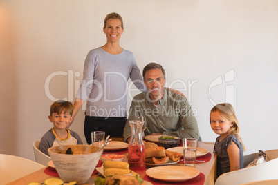 Happy family sitting on dining table at home