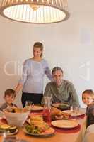 Family sitting on dining table at home
