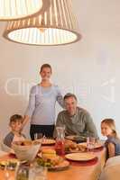 Happy family sitting on dining table at home