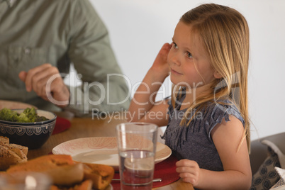 Girl with her father sitting on dining table