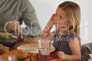 Girl with her father sitting on dining table