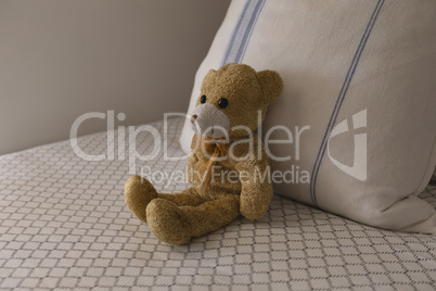 Teddy bear on a bed in bedroom at home