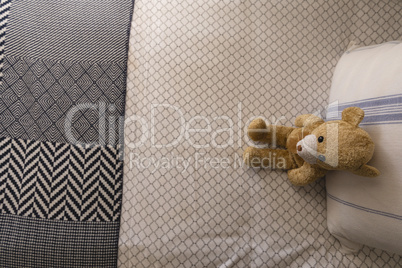 Teddy bear on a bed in bedroom at home