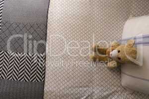Teddy bear on a bed in bedroom at home