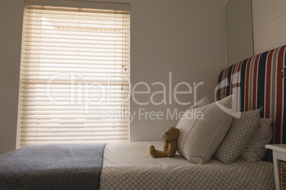 Teddy bear on a bed in bedroom Teddy bear on a bed in bedroom