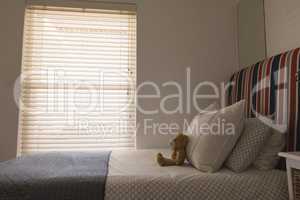 Teddy bear on a bed in bedroom