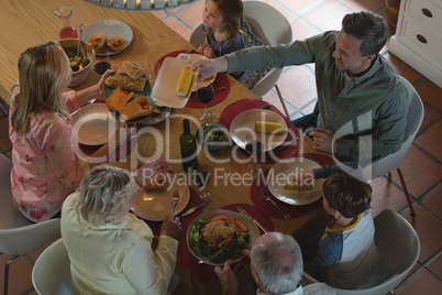 Multi-generation family having food on dining table