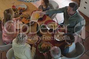 Multi-generation family having food on dining table