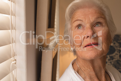 Senior woman looking up in bedroom