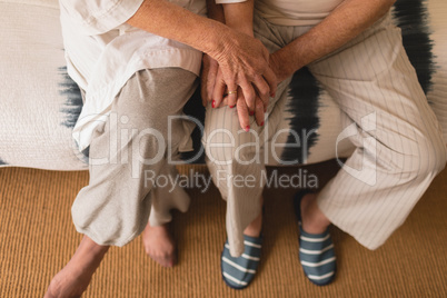 Senior couple holding hands in bedroom