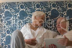 Senior couple using digital tablet in bedroom