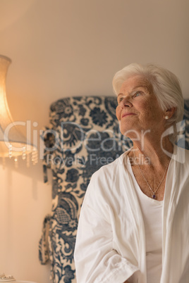 Senior woman looking up in bedroom