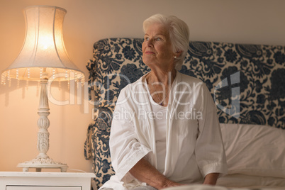 Thoughtful senior woman relaxing in bedroom