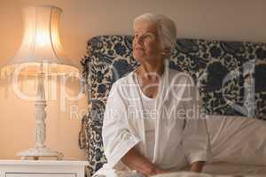 Thoughtful senior woman relaxing in bedroom