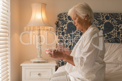 Senior woman having medicine in bedroom