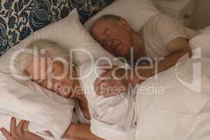 Senior couple sleeping together in bedroom