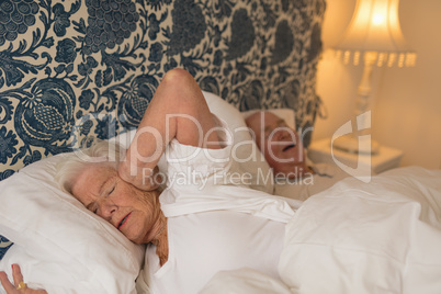 Senior couple sleeping in bedroom