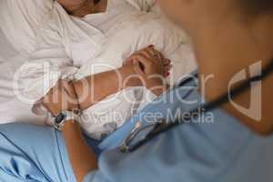Mid section of female doctor consoling senior woman