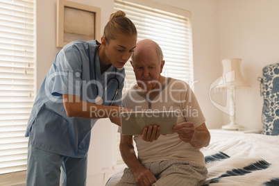 Female doctor and senior man using digital tablet