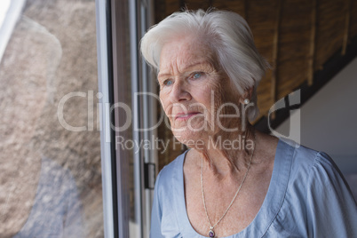 Senior woman looking through window