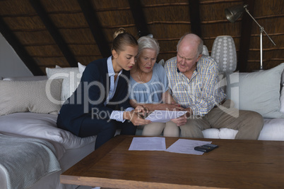 Female doctor and senior couple discussing over medical reports