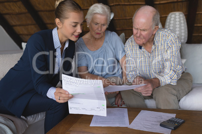 Female doctor and senior couple discussing over medical reports