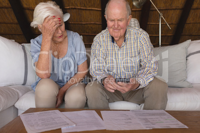 Worried senior couple discussing over medical bills