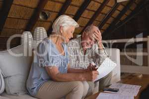 Senior couple discussing over medical bills in living room