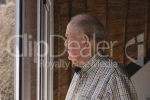 Senior man looking through window