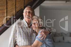 Senior couple embracing each other at home