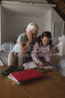 Grandmother helping her granddaughter with homework