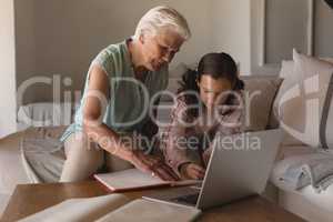 Grandmother helping her granddaughter with homework