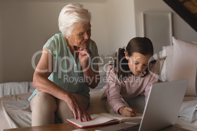 Grandmother helping her granddaughter with homework