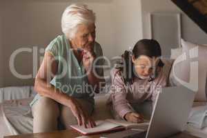 Grandmother helping her granddaughter with homework