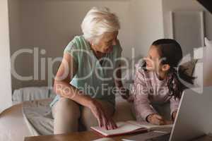 Grandmother helping her granddaughter with homework