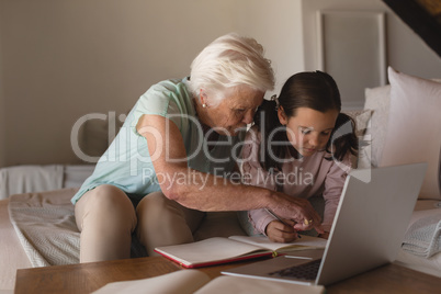 Grandmother helping her granddaughter with homework