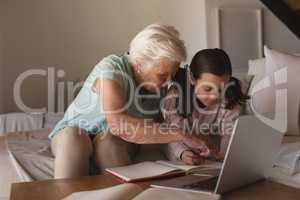 Grandmother helping her granddaughter with homework