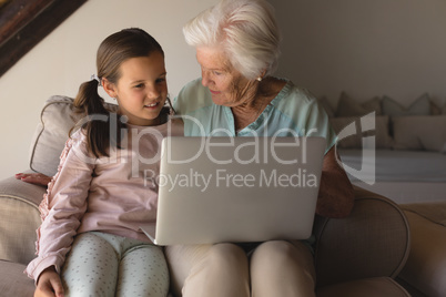 Grandmother and daughter discussing over laptop