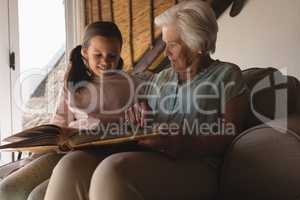 Grandmother and granddaughter looking at photo album