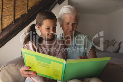 Grandmother and granddaughter reading story book