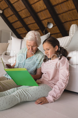 Grandmother and granddaughter reading story book