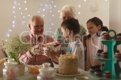 Multi-generation family giving present to birthday boy