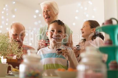 Multi-generation family eating cupcake at home