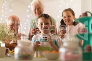 Multi-generation family having cupcakes at home