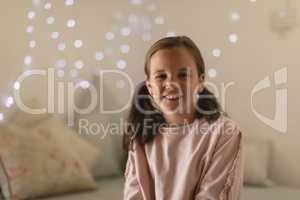 Innocent girl sitting in bedroom at home