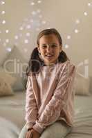 Innocent girl sitting in bedroom at home