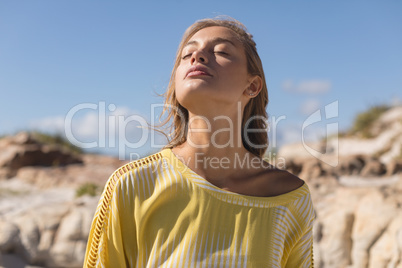 Beautiful woman standing with eyes closed at beach