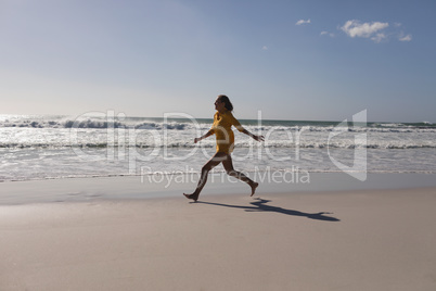 Woman running on the beach near seashore