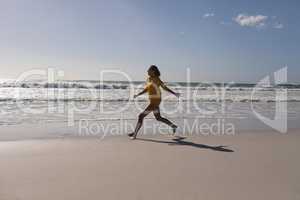 Woman running on the beach near seashore